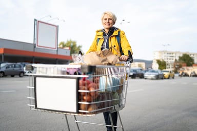 Person pushing a wagon in front of a supermarket.