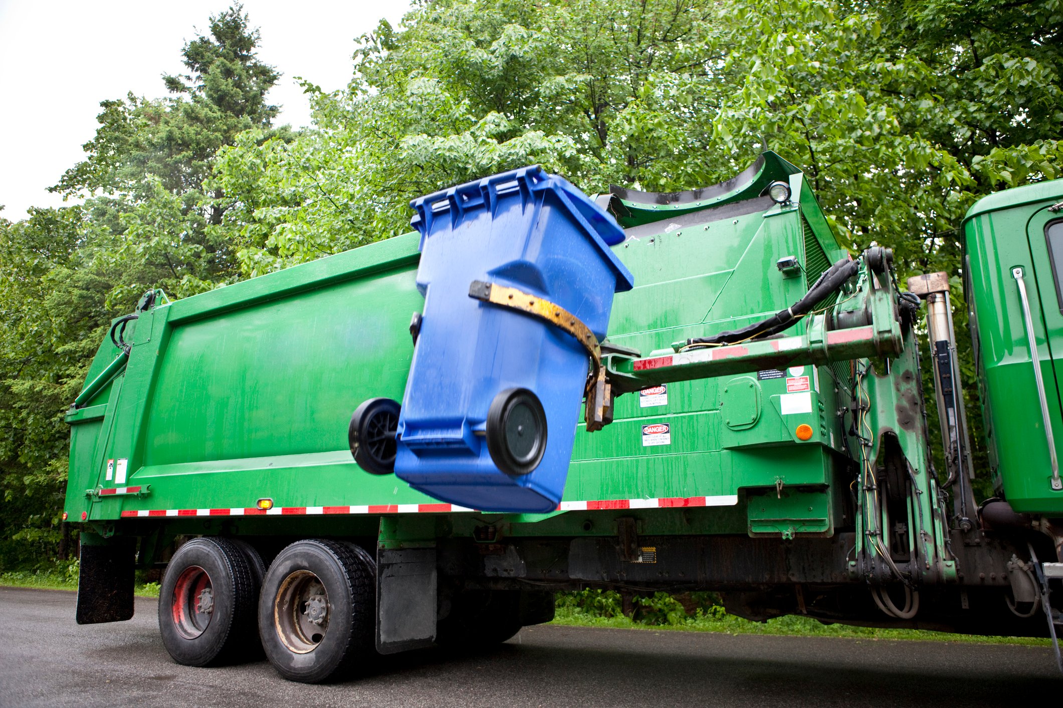 Recycling truck picking up a recycling bin.