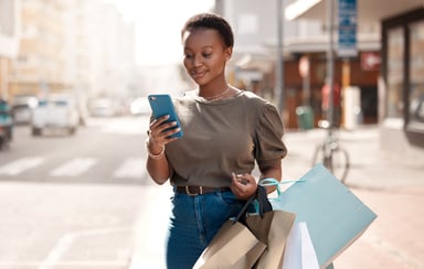shopper carries bags and shops on phone