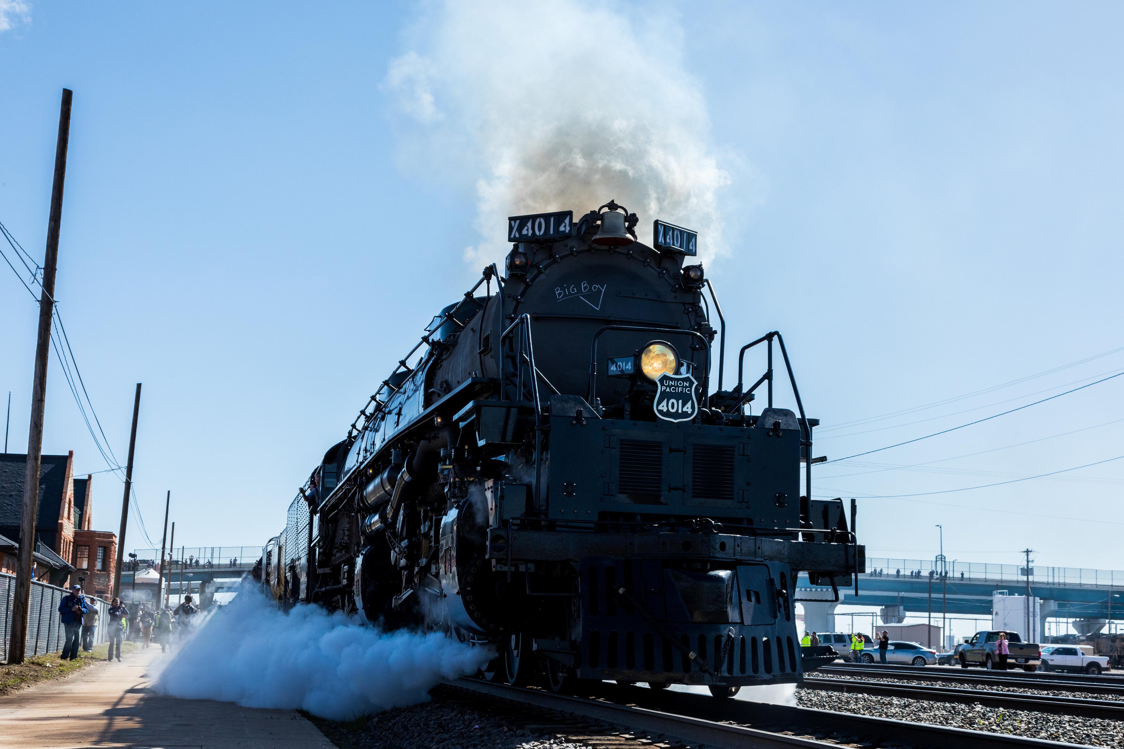 Union Pacific train chugs past with steam rolling out of engine.