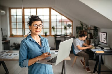 Young Lady Standing with Laptop in Home Office