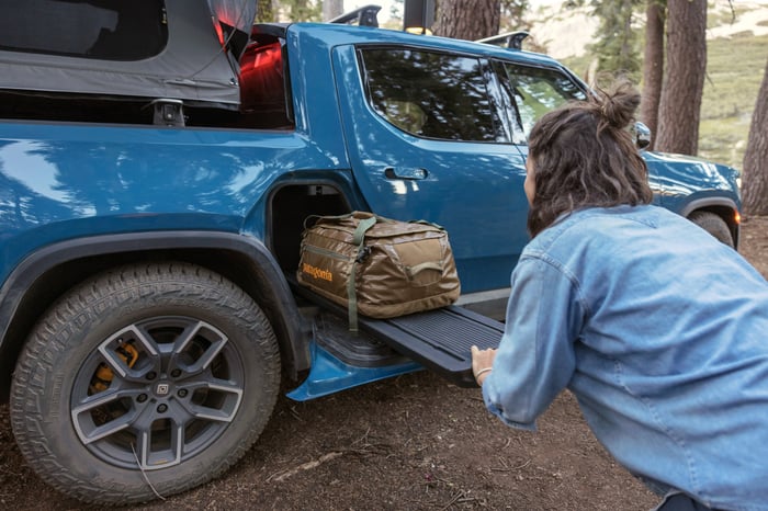 Person stowing gear in a pickup truck.