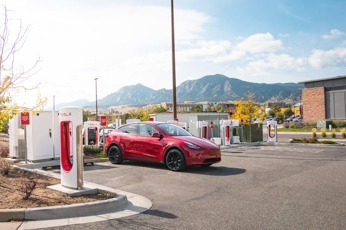 Red Tesla charging at Supercharger site. 