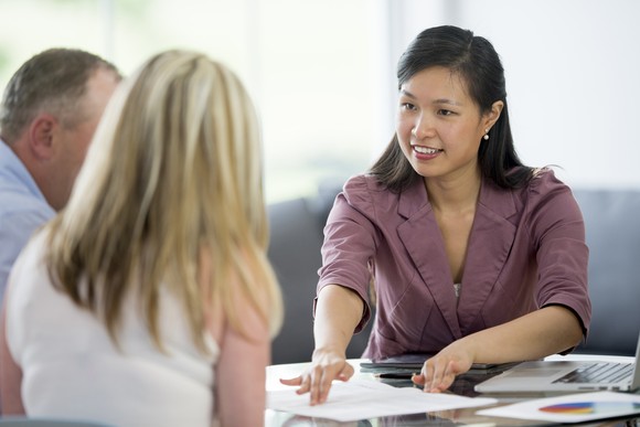 Two people speaking with a financial professional about retirement planning.