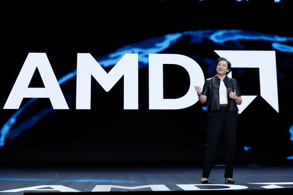 AMD CEO Lisa Su on a stage with the AMD logo behind her.