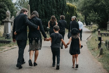 Grieving family walking through a cemetery