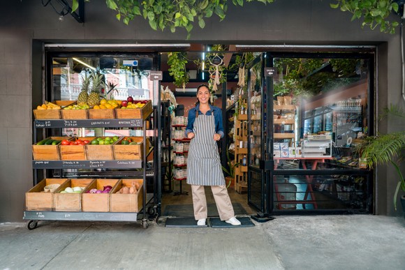 Person standing in doorway of food market.