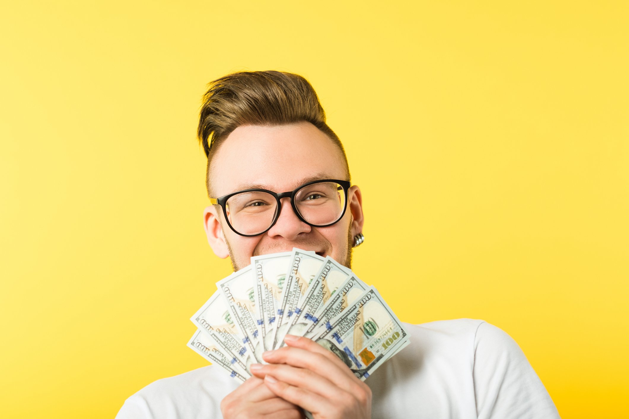 Getty - man with cash money dollars dividends happy