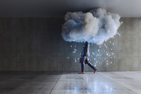 Person in a suit carrying a briefcase surrounded by a cloud with binary digits falling from the cloud like rain drops.