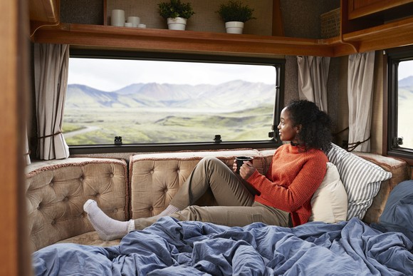 Someone looking out the window of a parked RV.