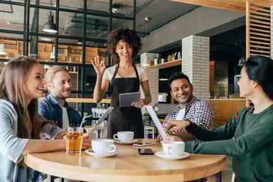 waiter taking orders from a group around a table