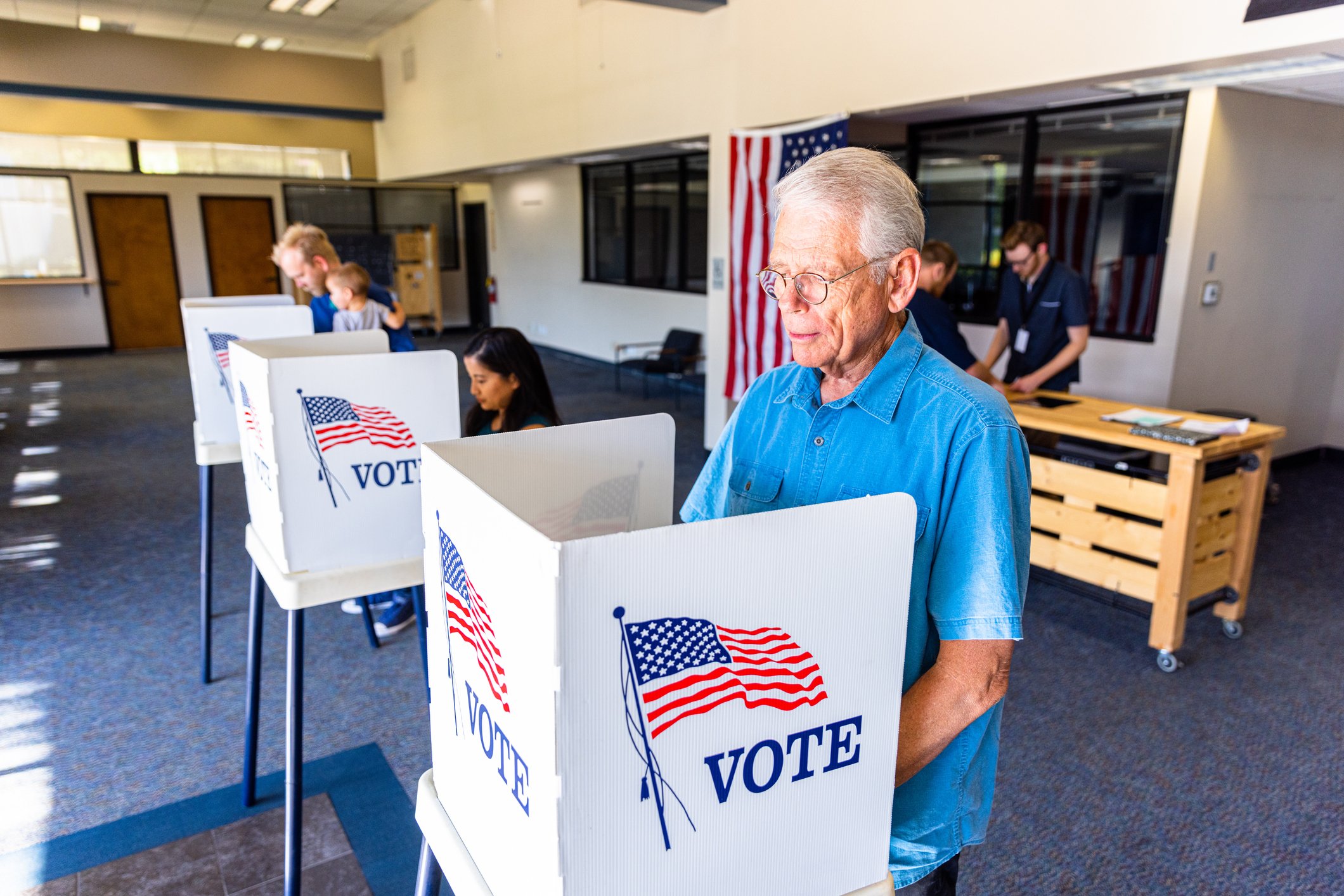 People standing at voting booths.