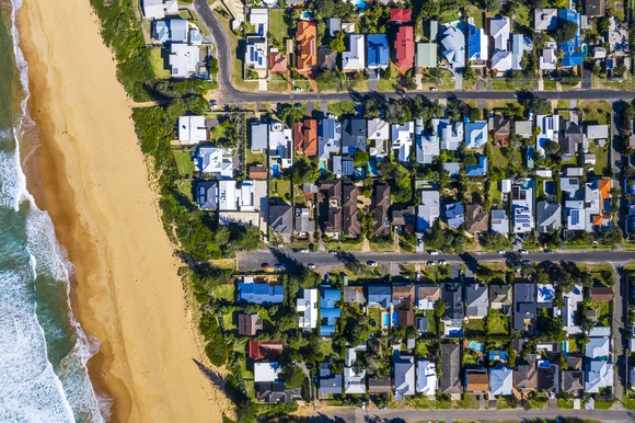 Aerial view of houses built along a coastline. 