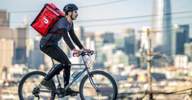 A Dasher delivers a DoorDash order on a bike