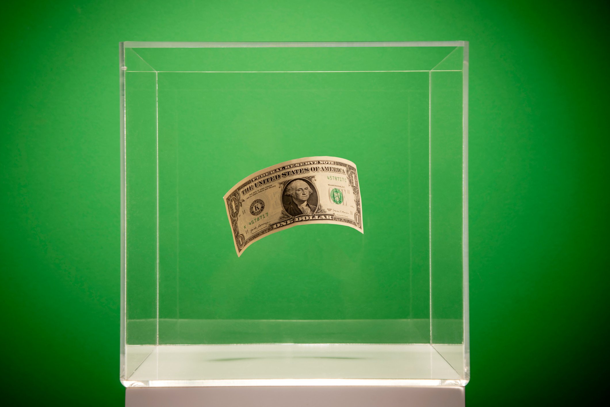 Dollar bill in a glass container.