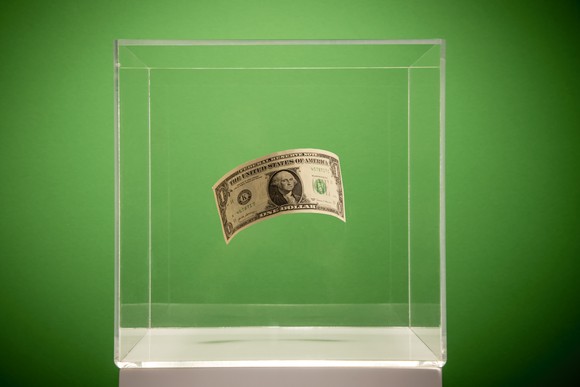 Dollar bill in a glass container.