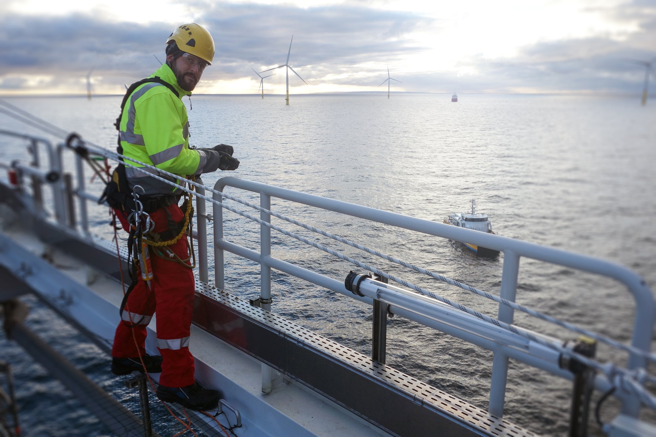 A rope-access technician makes inspection and repairs of infrastructure associated with an offshore wind farm. 