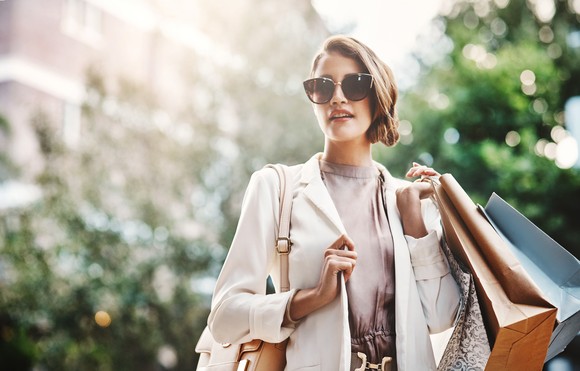 An affluent shopper holds several shopping bags.