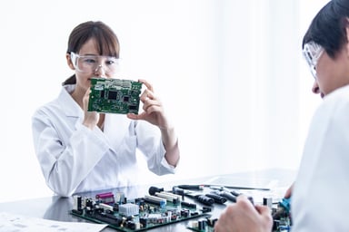 Woman in specs holding an integrated circuit