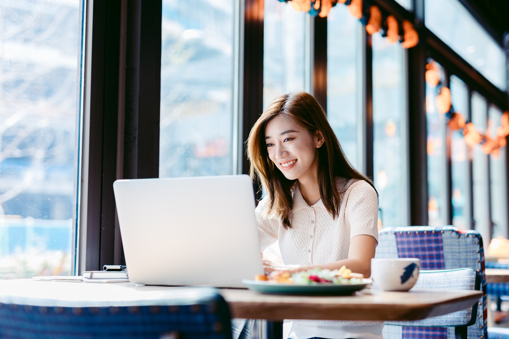 Person using notebook computer in a cafe.