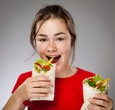 child holds burrito half in each hand