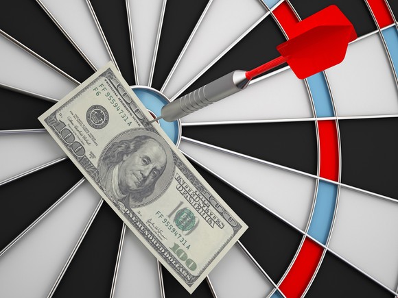 Dollar bill pinned to a dart board. 