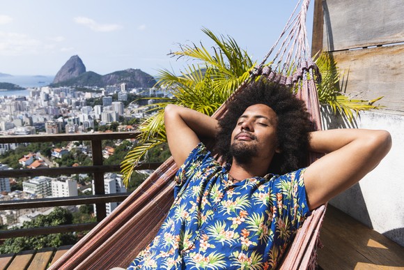 A man relaxing in a hammock wearing a Hawaiian shirt
