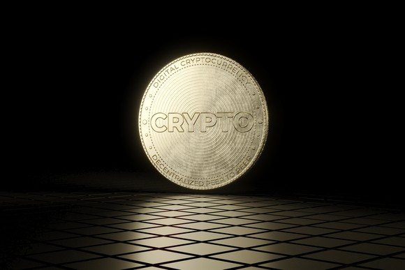A gold coin with the word "crypto" on it.