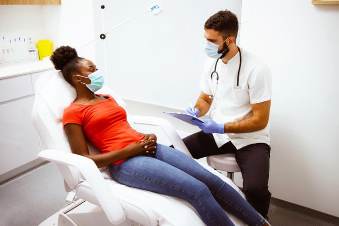 A doctor and patient converse at an appointment.