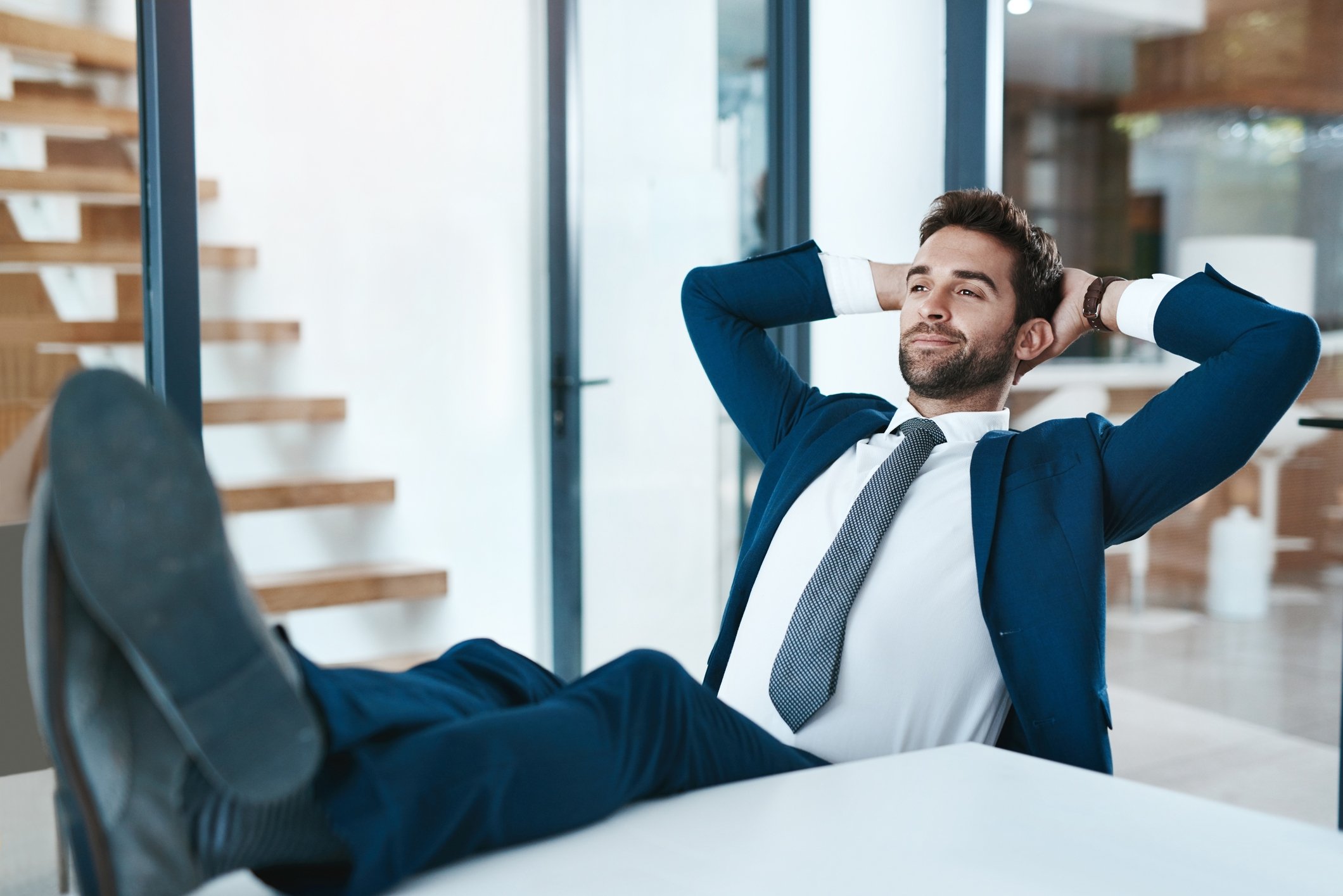 A person sitting in an office with their feet on the desk.