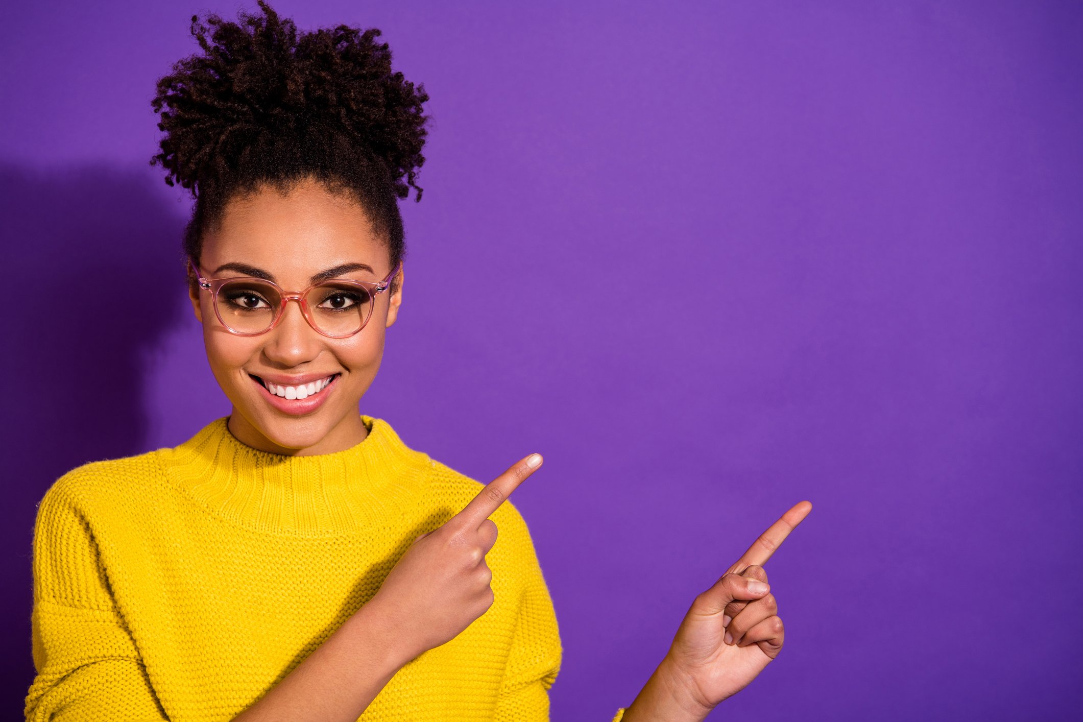 Someone is smiling and pointing up and to her left.