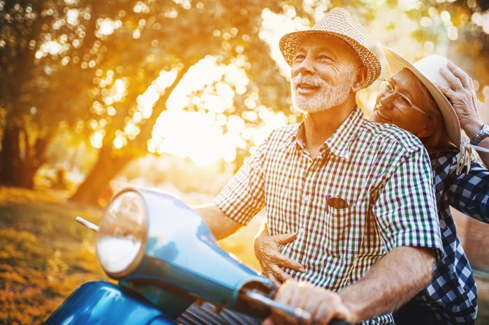 Two people riding a motor scooter.