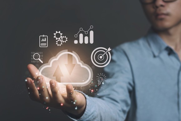 Hand holding digital representations of cloud computing.