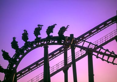 People upside-down in rollercoaster at sunset 