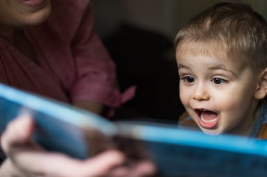 A child reacts enthusiastically to a storybook.