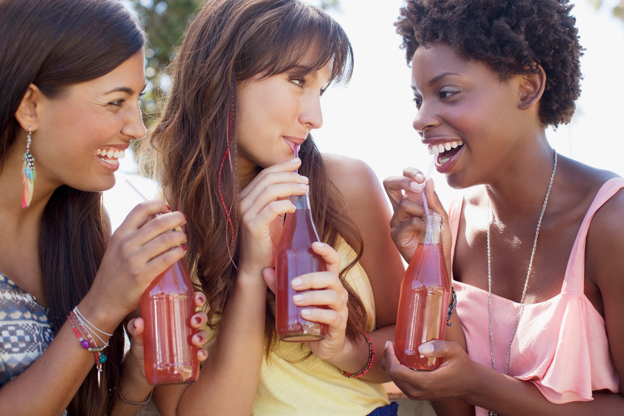 Three friends enjoying soft drinks.