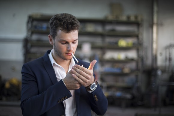 A person lights up a cigarette.