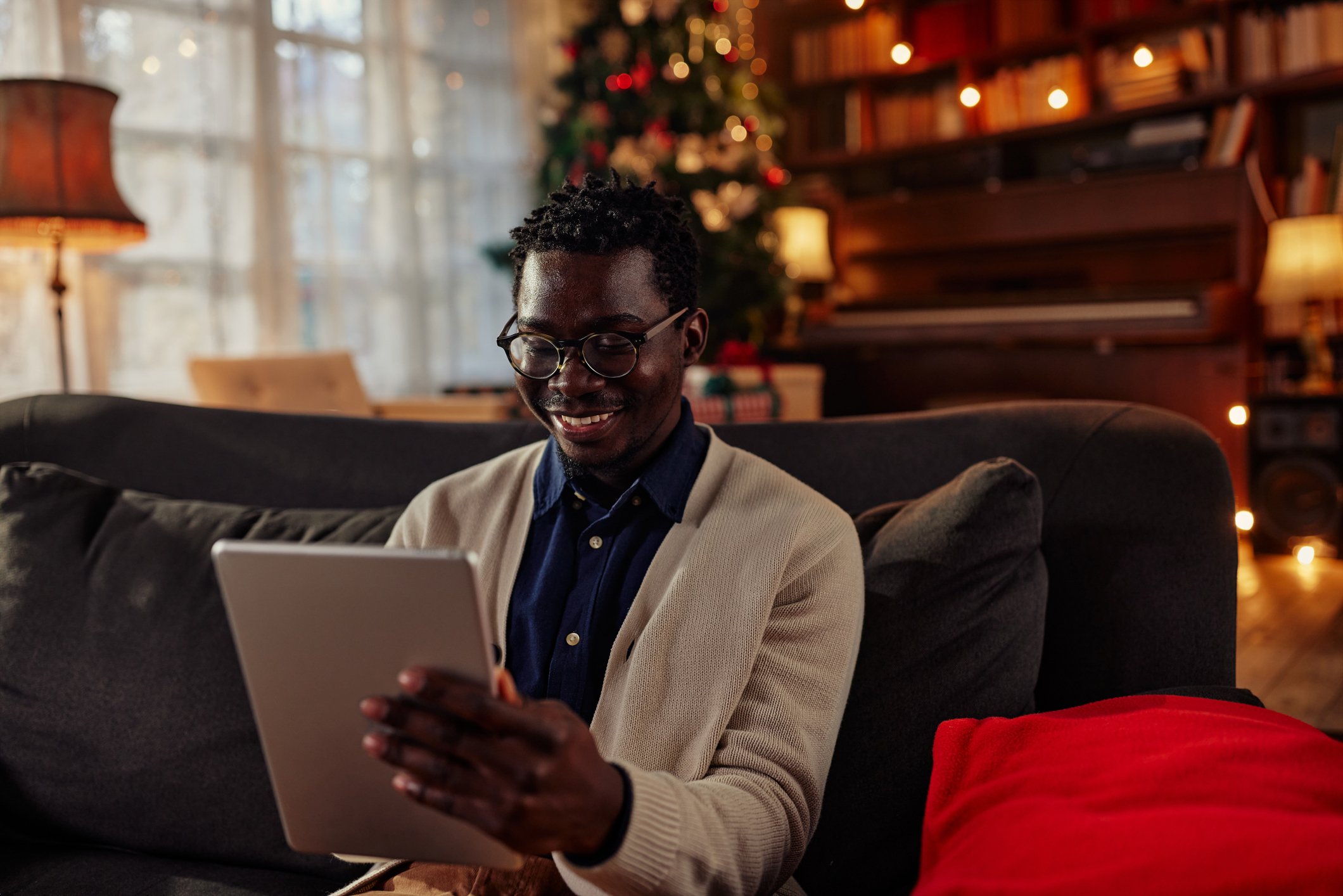 A person looking at a tablet, smiling.