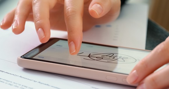 Person providing a digital signature to a document on a smartphone.