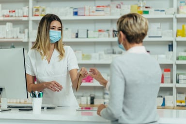 A pharmacist serves a customer