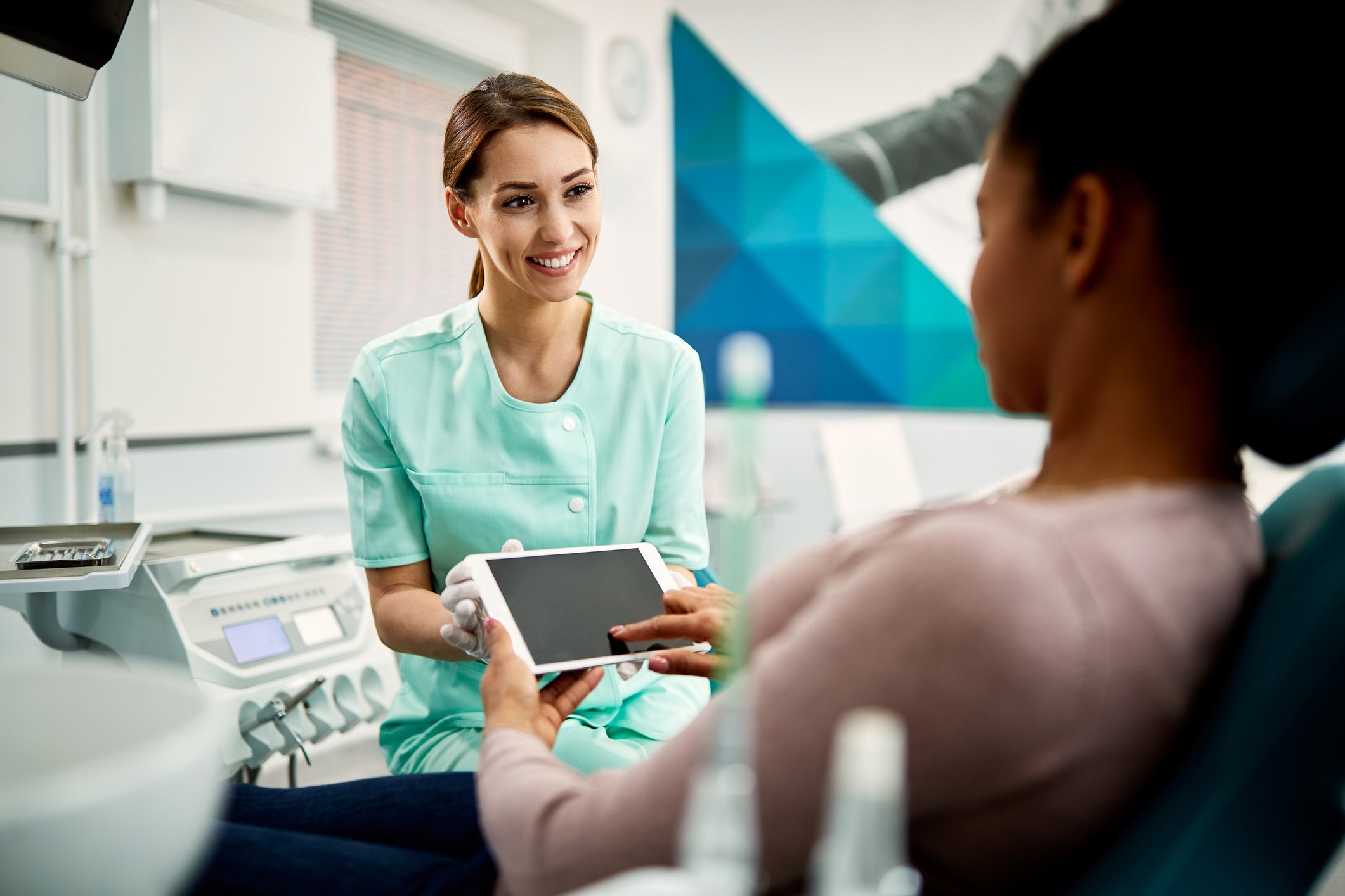 A patient electronically signs a tablet at a dentist's office.