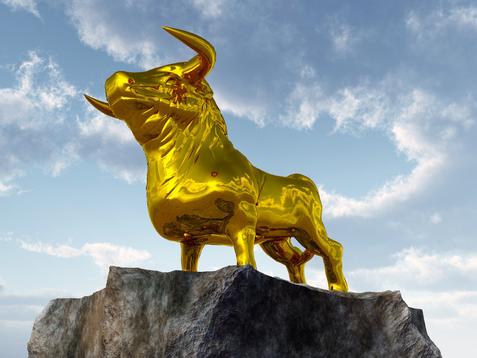 A golden bull statue on top of a cliff.