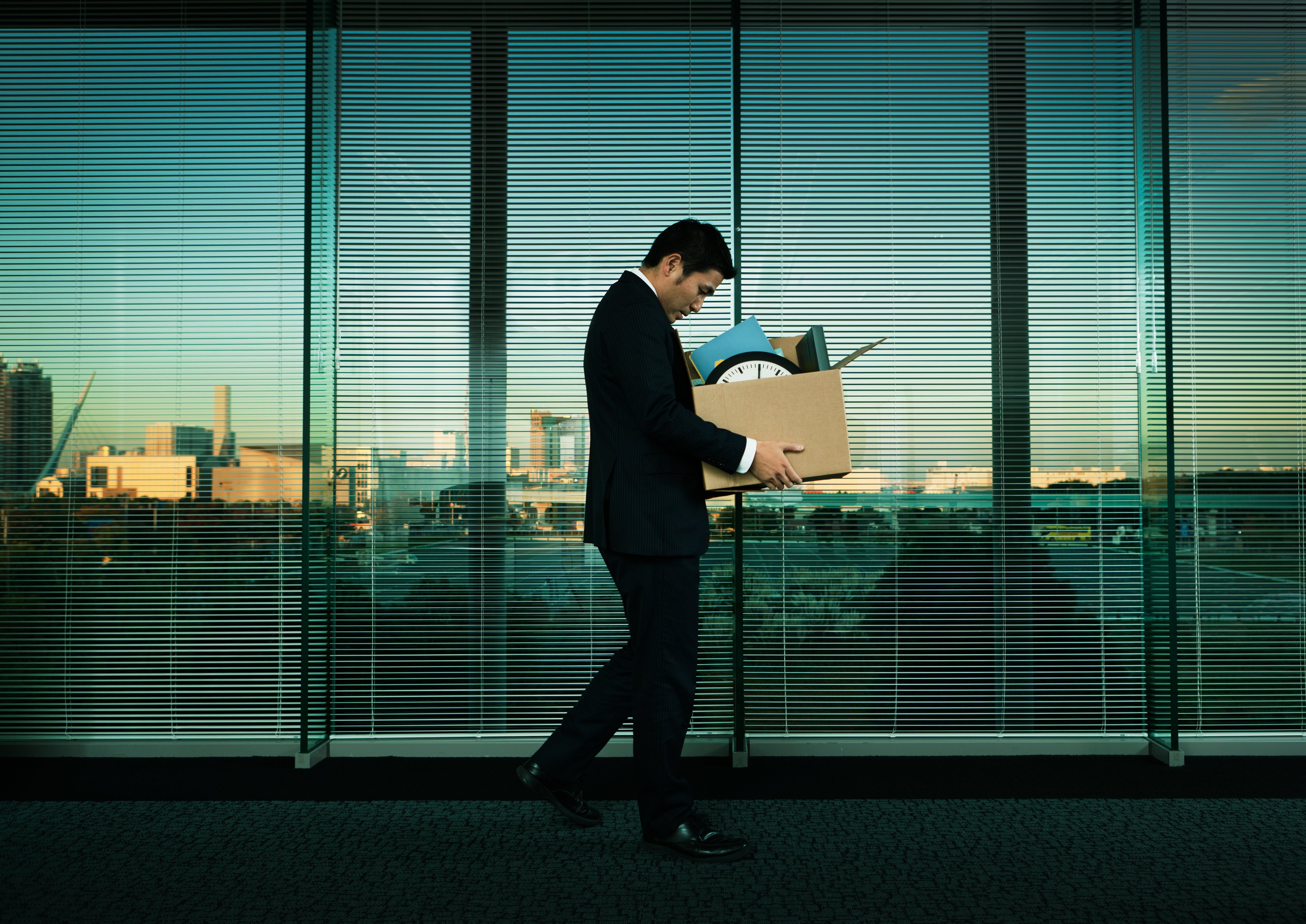 Fired worker in suit leaving office.