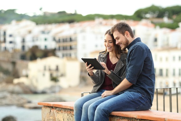 A couple watches a video on a tablet computer.