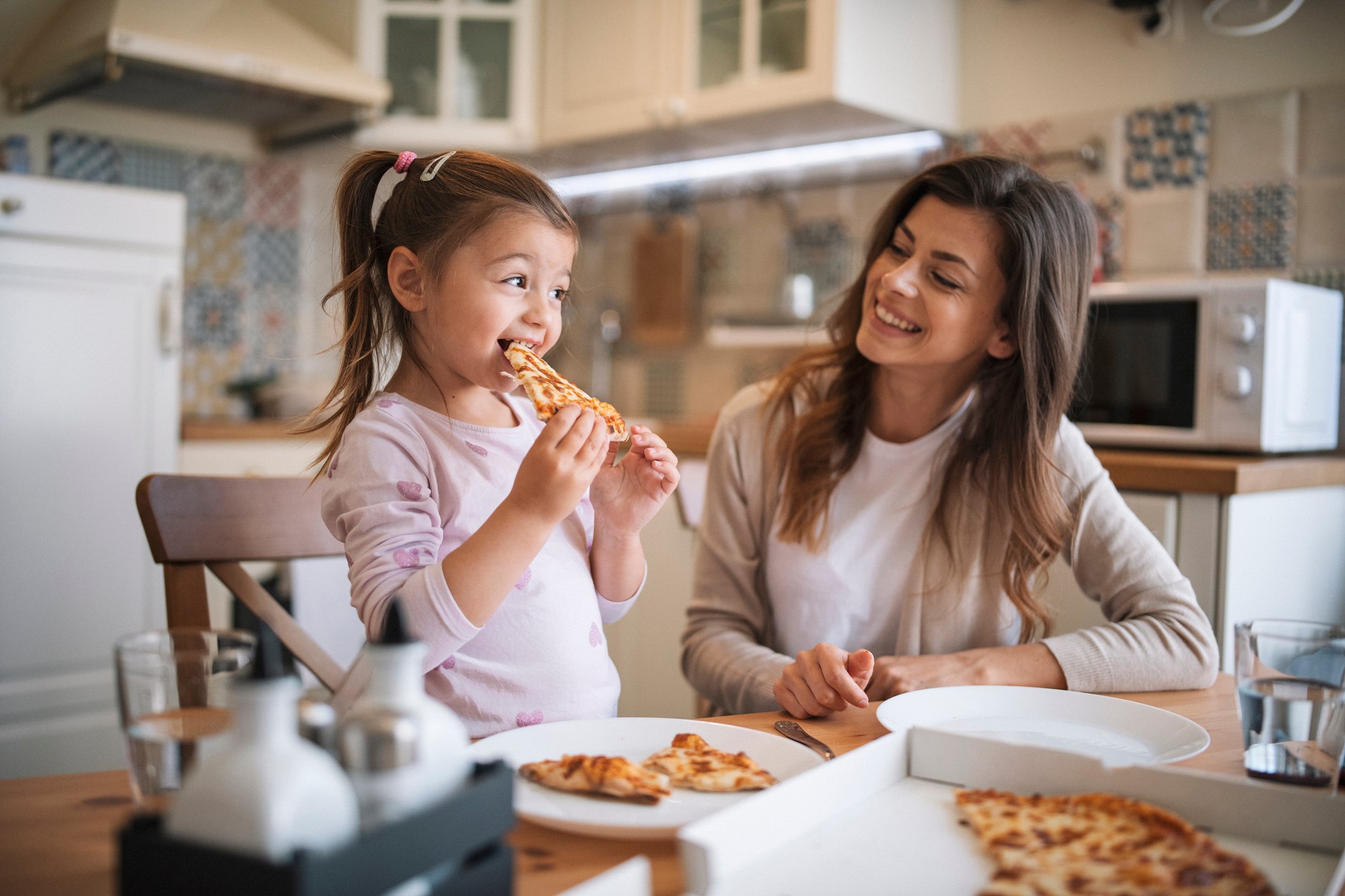 Mother and daugther enjoying pizza at home