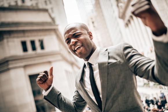 Investment professional celebrating on Wall Street.