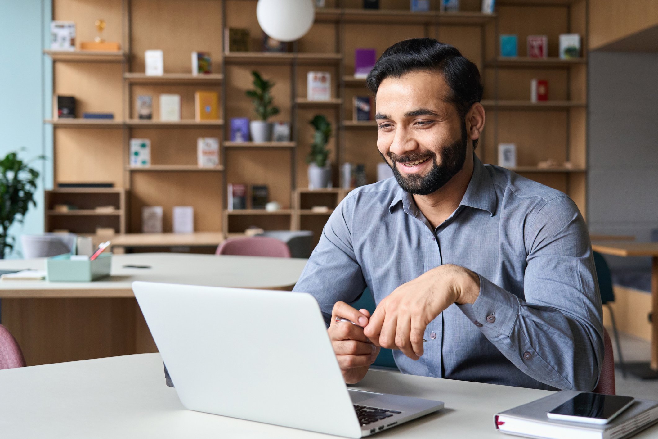 A person looking at a computer and smiling.