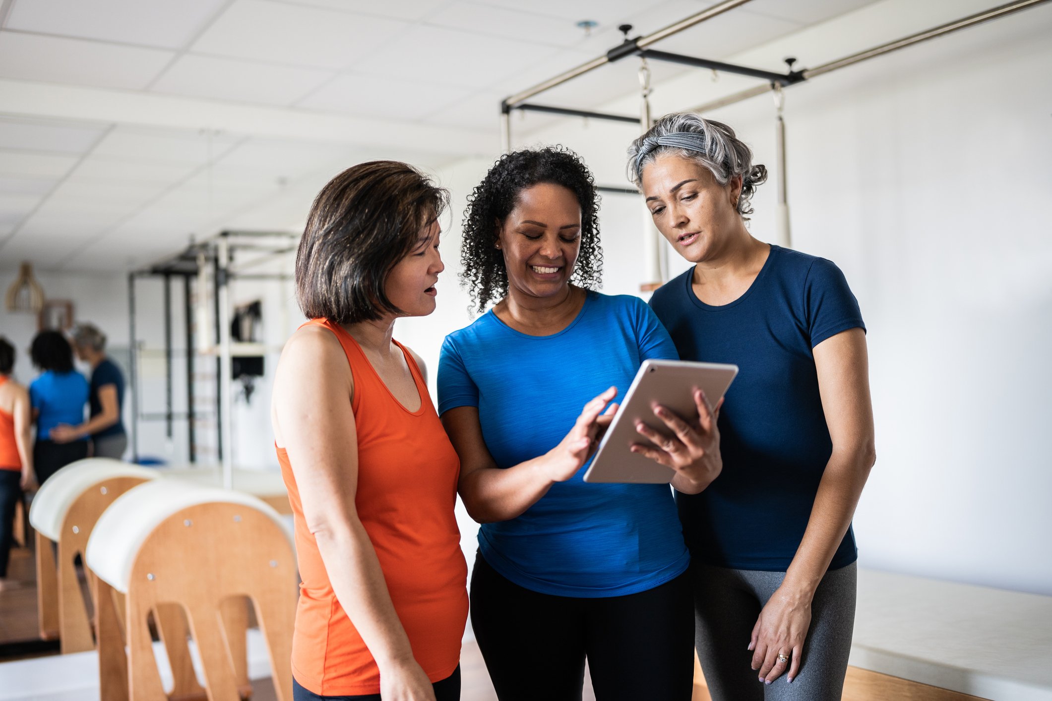 Three people looking at a tablet.