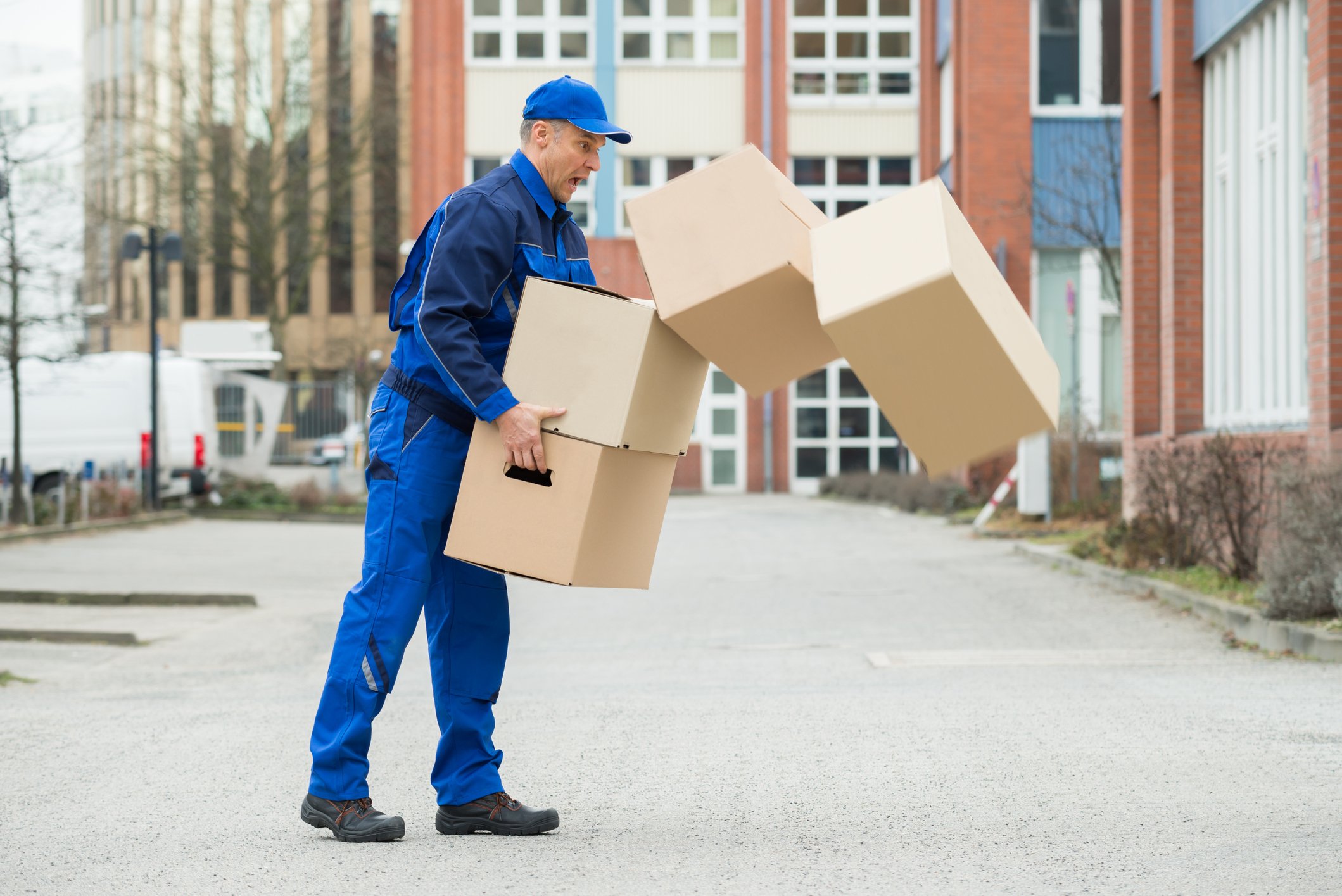 Delivery man dropping a stack of boxes.