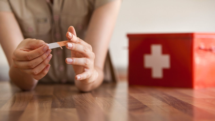 Person putting bandage on their finger.